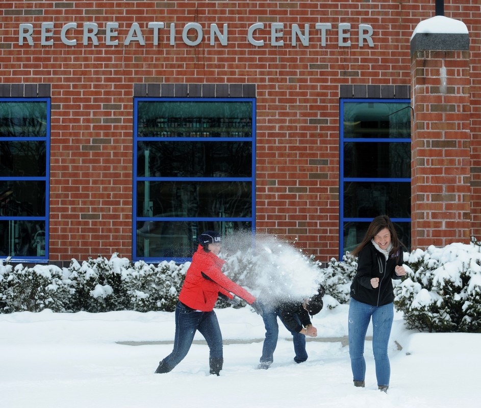 UMass Lowell students have a snowball fight outside the Campus Recreation Center.