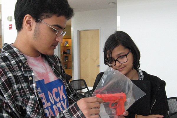 Students inspect a toy gun that's an exhibit in the CSI: Lowell fictional crime contest