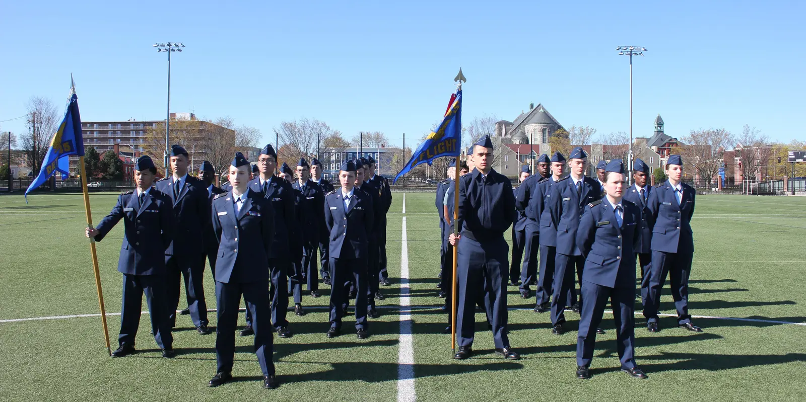 AFROTC cadets standing in formation on UMass Lowell field.