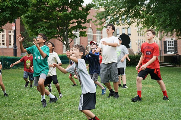 Summer campers at the Tsongas Industrial History Center play outdoor games in Boardinghouse Park