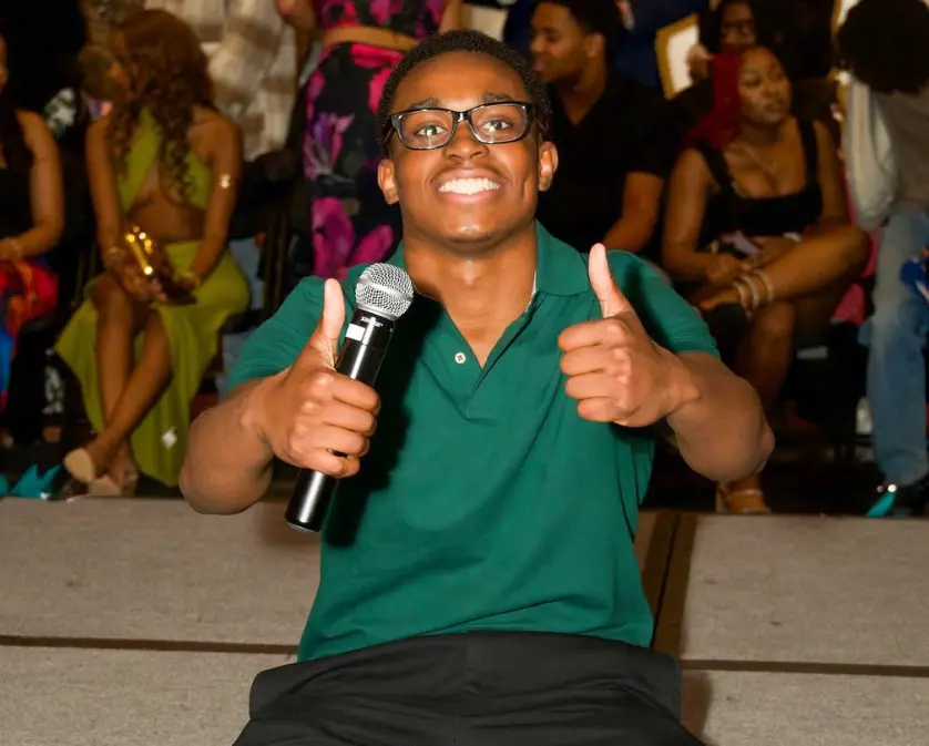Student giving a thumbs up at a club event.