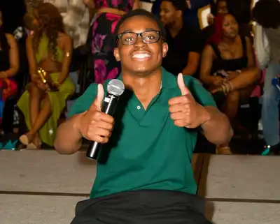 Student giving a thumbs up at a club event.