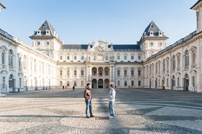 Two people stand in a nearly empty courtyard