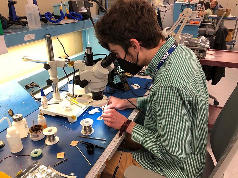 Thomas Cecelya working on microscope during his Zoll co-op