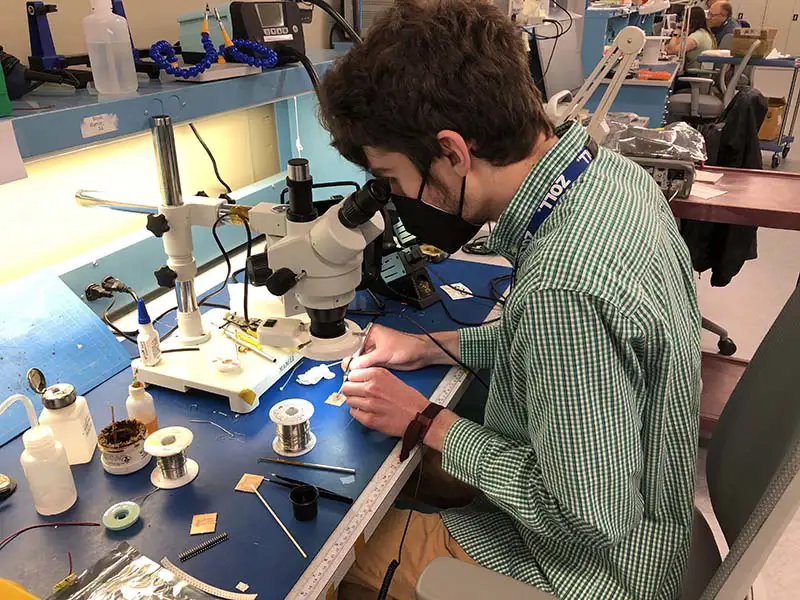 Thomas Cecelya working at a microscope during his Zoll co-op