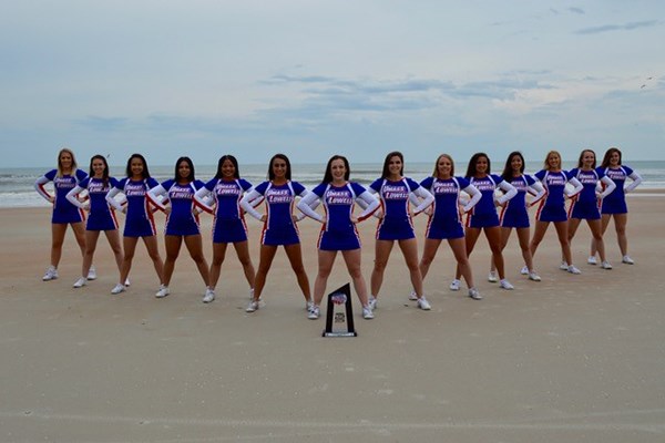 The UML cheerleaders pose with their fourth-place trophy on the beach in Florida