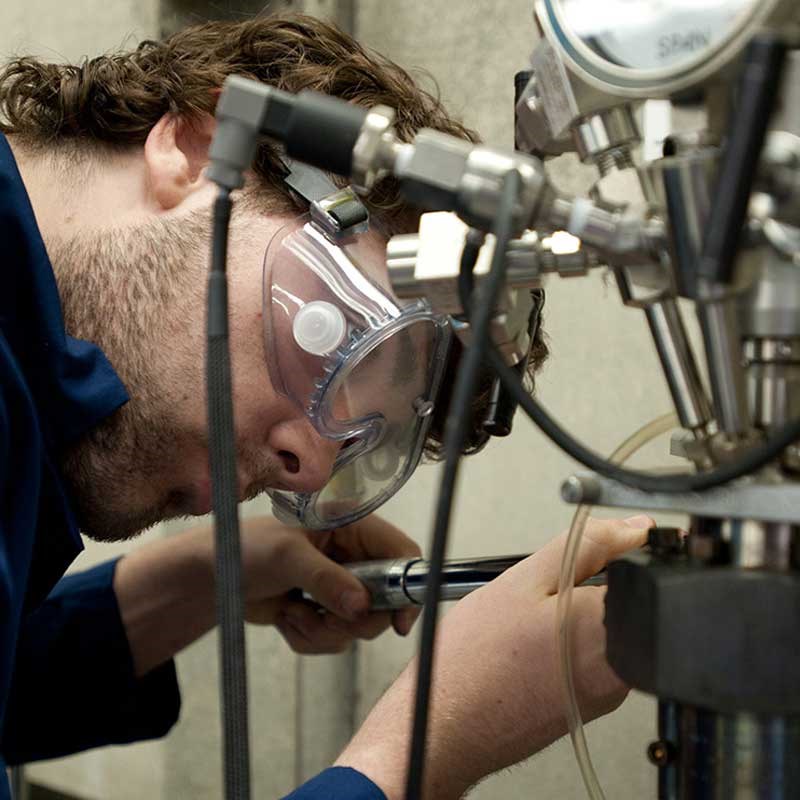 A UMass Lowell chemical engineering student working on equipment