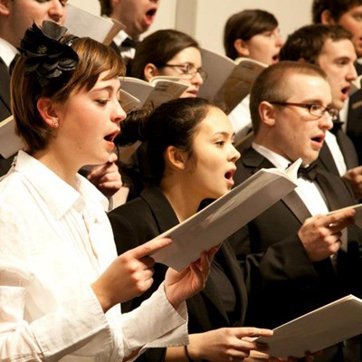 Students singing holding music sheets