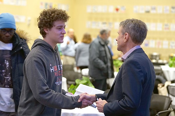 Chris Laszlo shakes hands with a student after signing his book