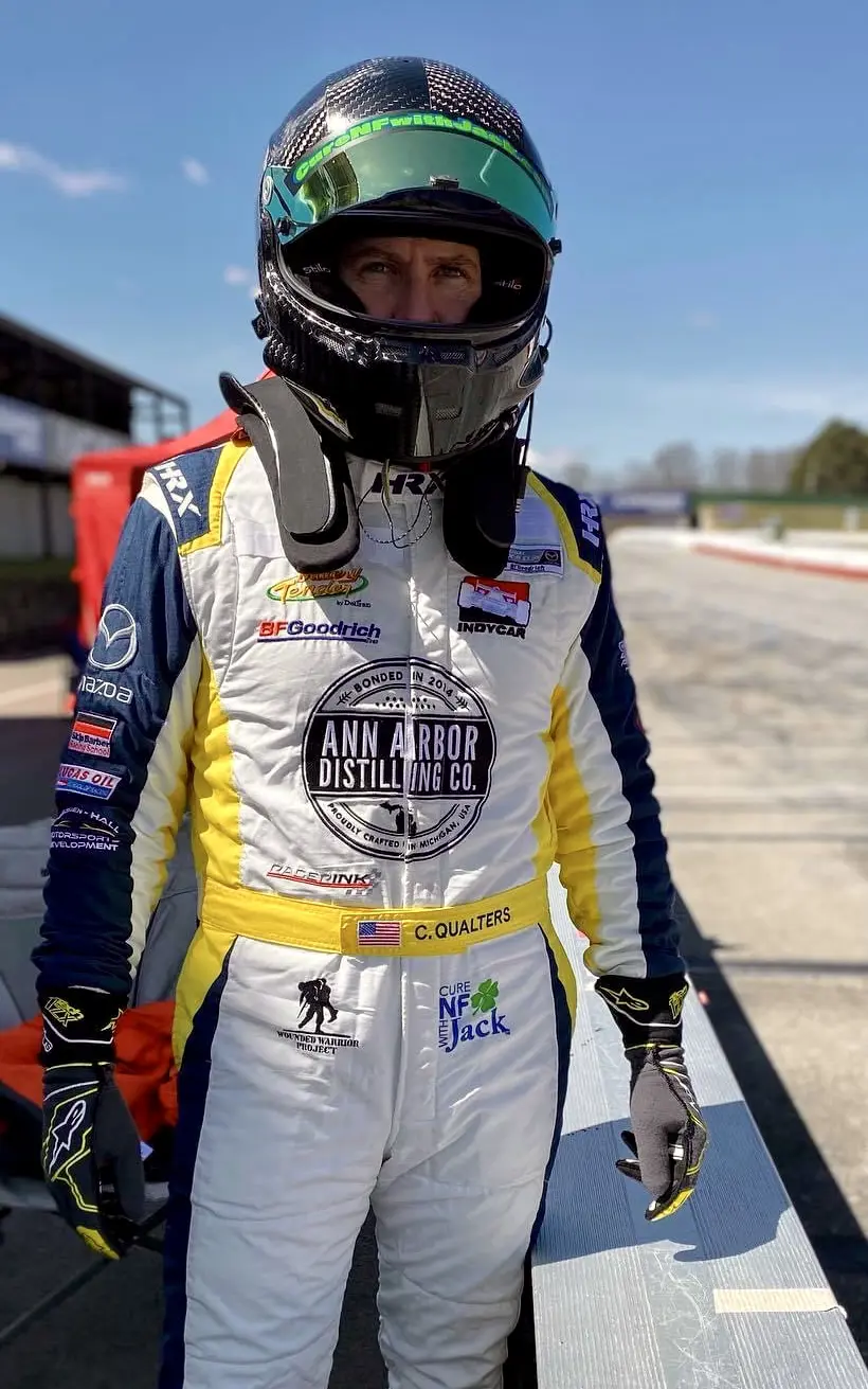 Chris Qualters in helmet and car racing jumpsuit