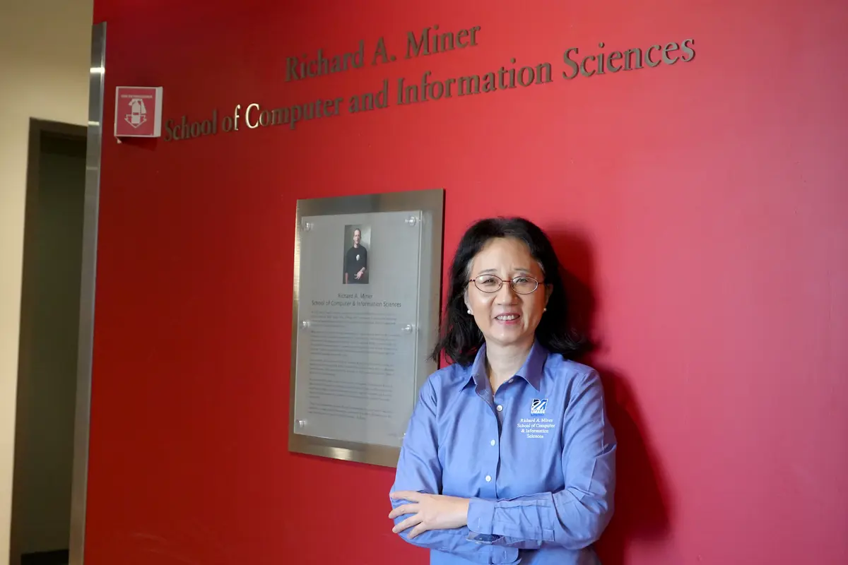 Cindy Chen poses in front of the Miner School sign.