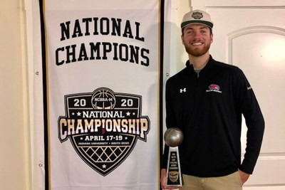 Club president Matt Maslowski poses with the team's championship banner and a trophy