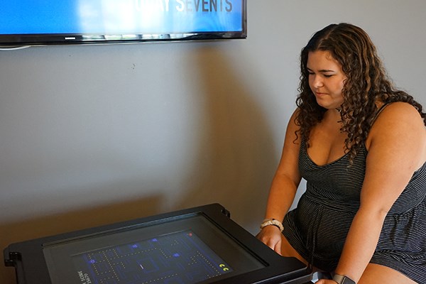 Stpehanie Carnazzo plays on the new Pac-Man machine outside the Student Activities office at UMass Lowell
