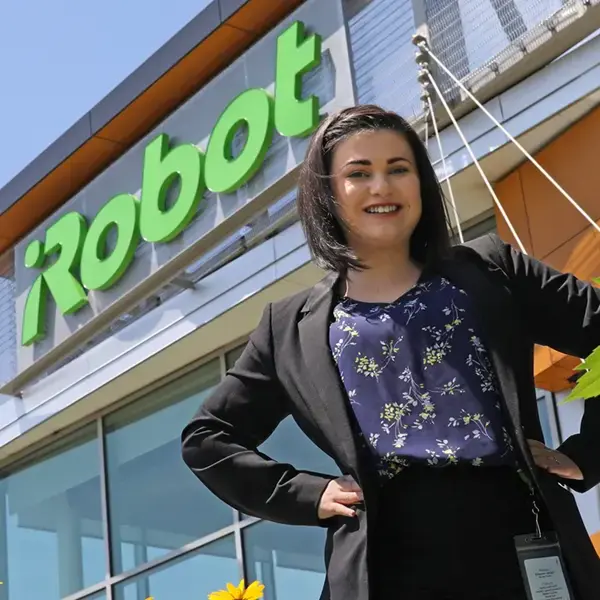 Student poses in front of the iRobot building.