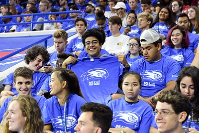 A student holds up his Convocation T-shirt in the stands