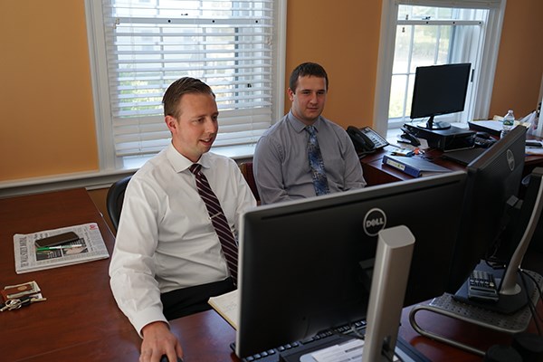 Alum Ethan Brown works with intern Nick Salema at the Cox Capital office