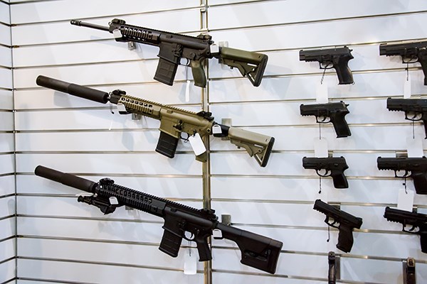 Rifles and handguns mounted on a wall in a gun shop
