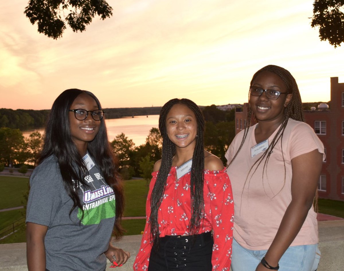 Three DC CAP students posing in front of the sunset. The UMass Lowell DC-CAP Scholars program supports students who were involved in the DC-CAP program in high school.