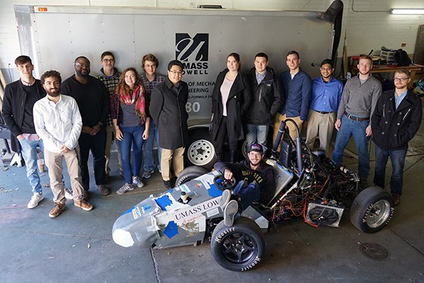 Business and engineering students pose with the River Hawk Racing car