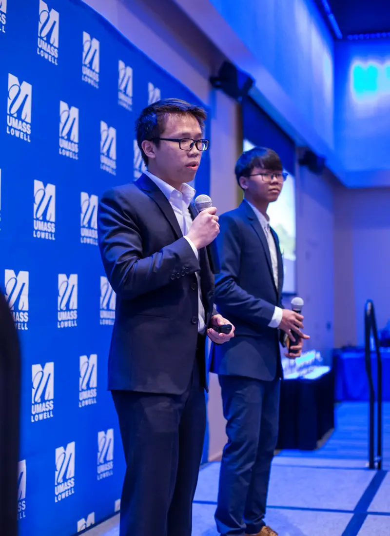 Thanh Hoang and Trung Nguyen onstage pitching DEXTER, the pesticide-spraying robot