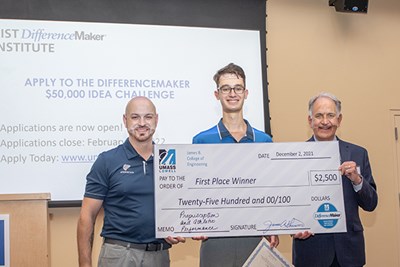 Three men smile and hold an oversized first-place check 