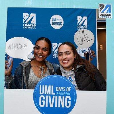 Two young women smile in Days of Giving frame