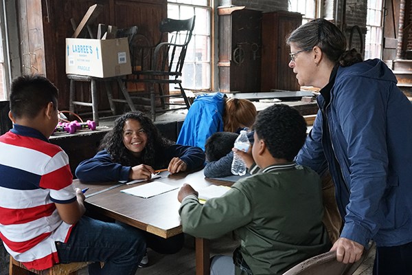 Rising Loaves director Mary Guerrero and small group leader Lidyanette Gonzalez work with students in the carpenter shop.
