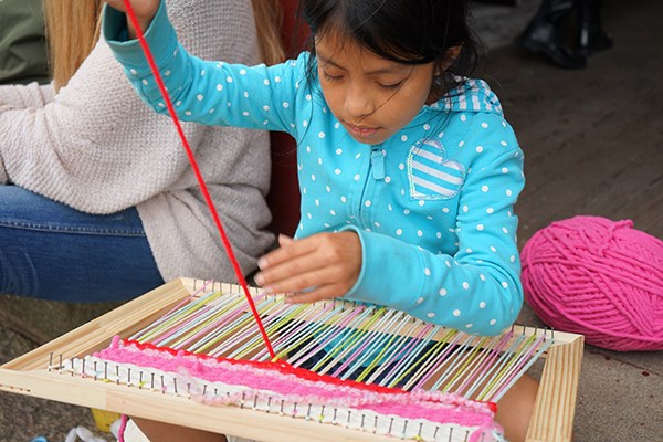 Jennifer Merida works on her weaving during "Choice" time at the Rising Loaves summer camp