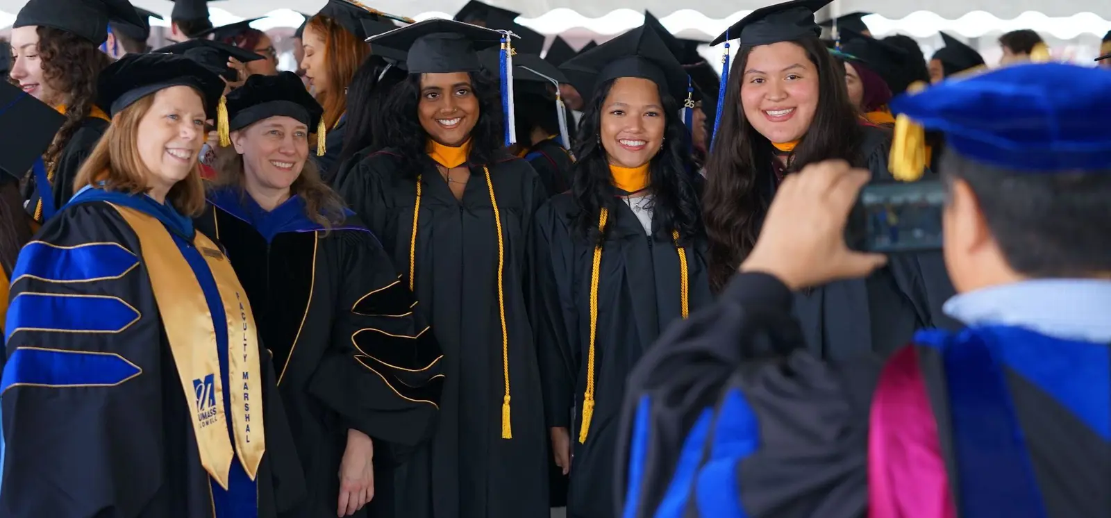 faculty members and students pose for photo in their regalia