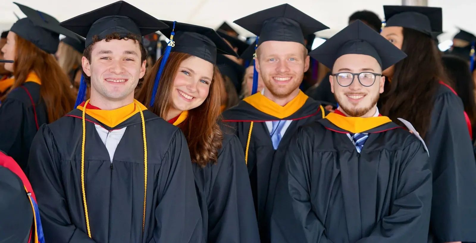 Four students in caps and gowns