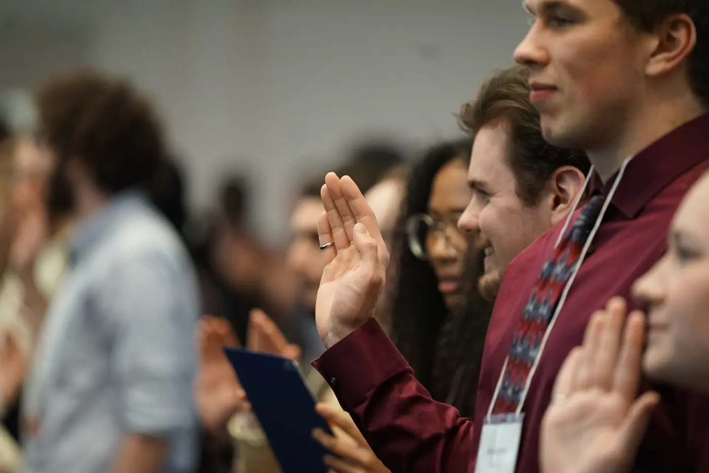 Students raise their hands while reciting an oath.
