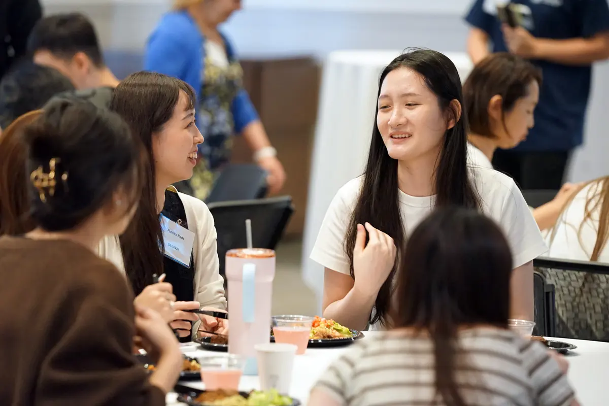 Two women talk while seated at a table having lunch.