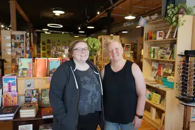 Two women standing in bookstore. 