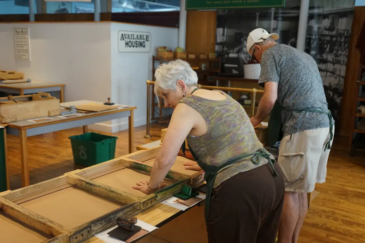 Man and woman working on press machine.