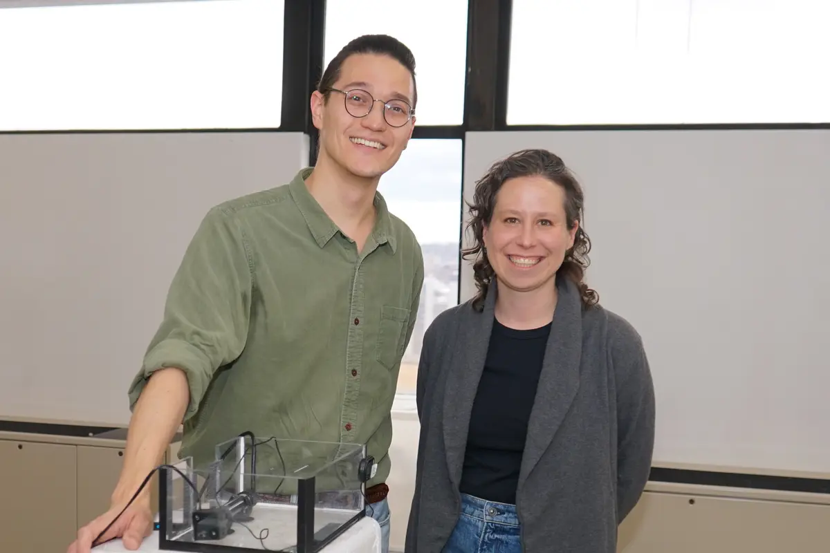 A man and a woman pose for a photo in a biology lab.