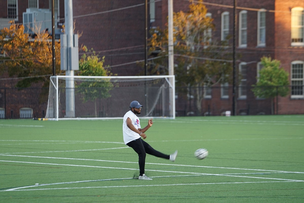 Man kicking soccer ball on rec field