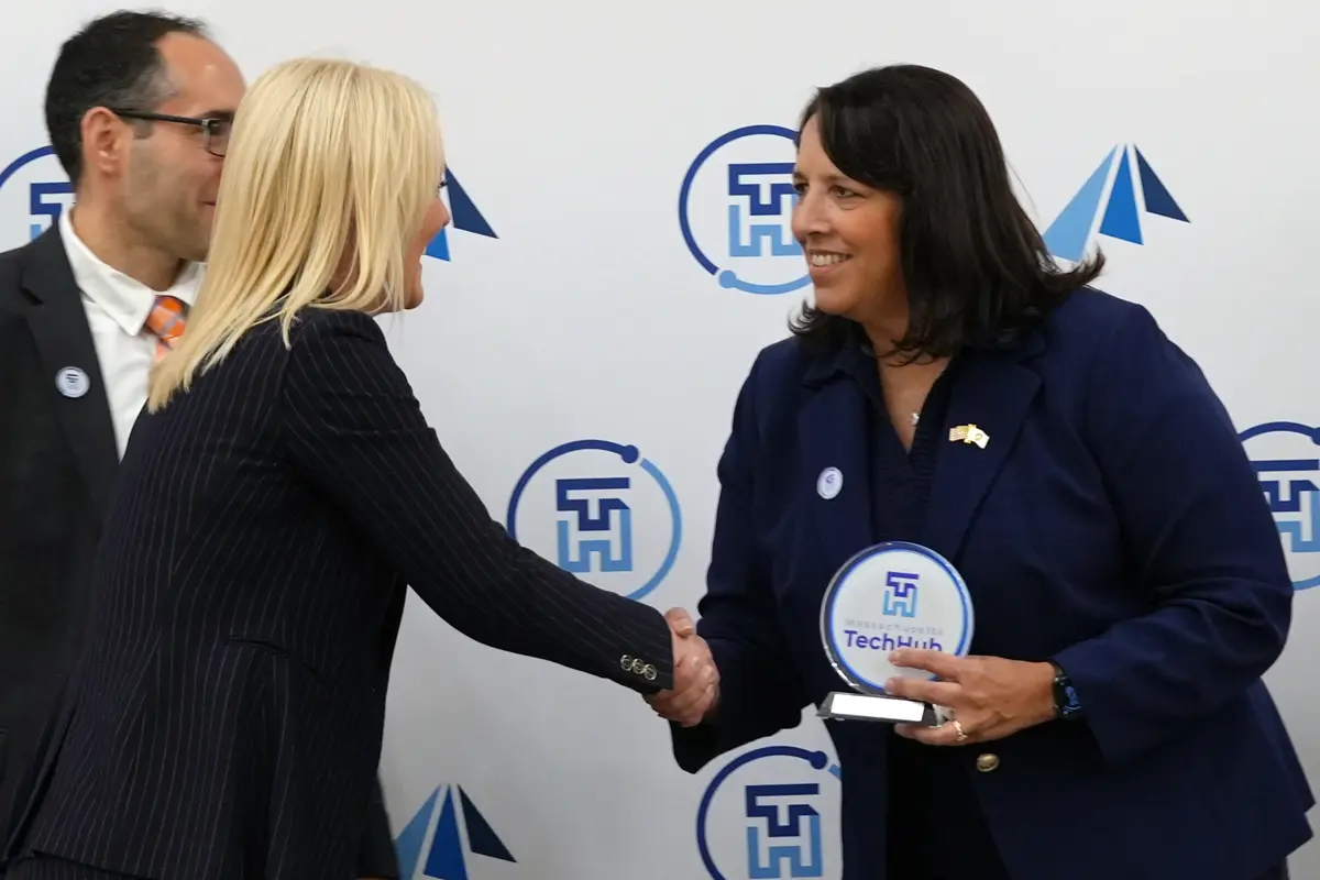 Kim Holloway accepts an award from Kim Driscoll.