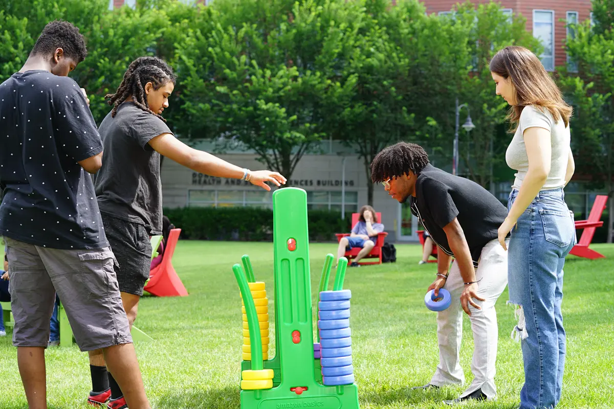 Students play Connect 4 at a Understanding Power, Resisting Injustice, Summer Experience cookout.