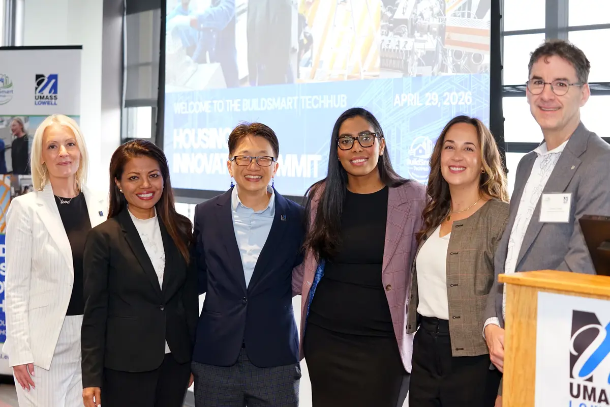 Six people stand together at a housing innovation summit.