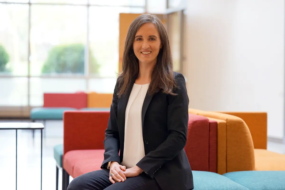 A woman poses for a photo in the lobby of a building.