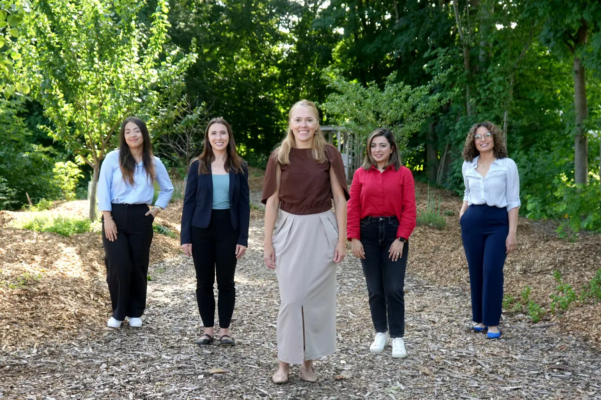 Five people stand in a food forest.