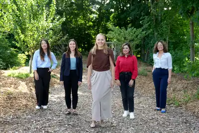 Five people stand in a food forest.