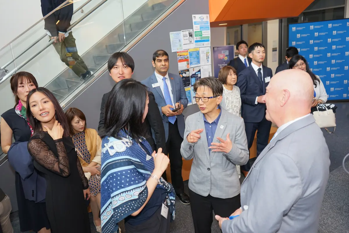 People stand and chat in the lobby of a building.