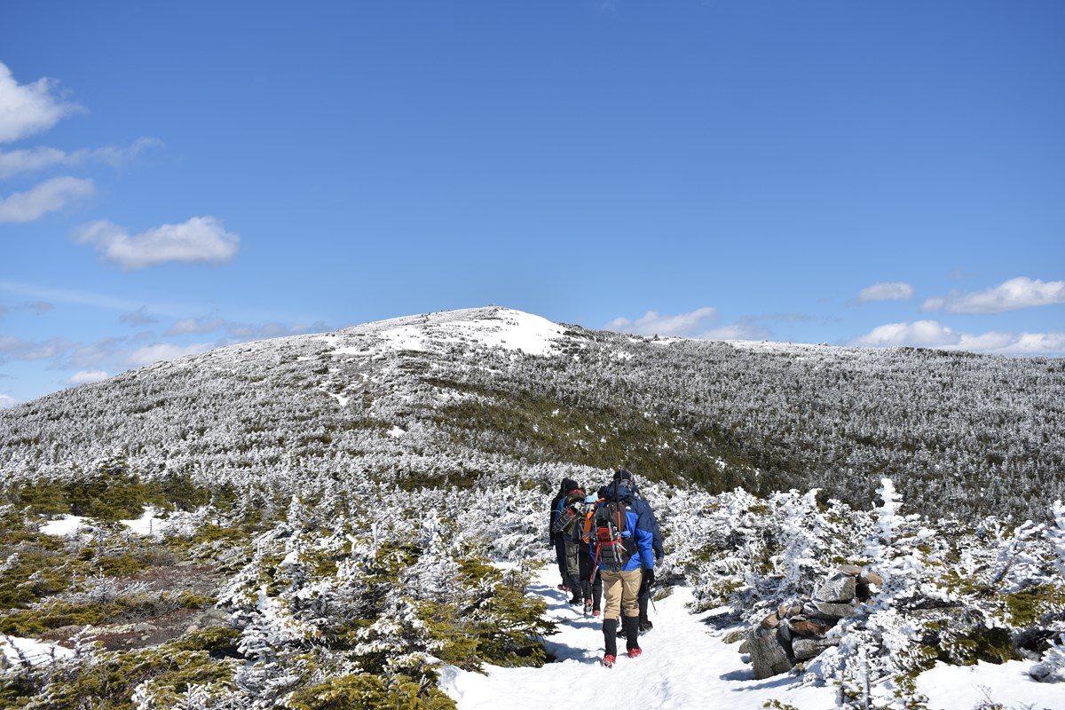 Hikers in the Snow Headed for a Mountain Summit.
