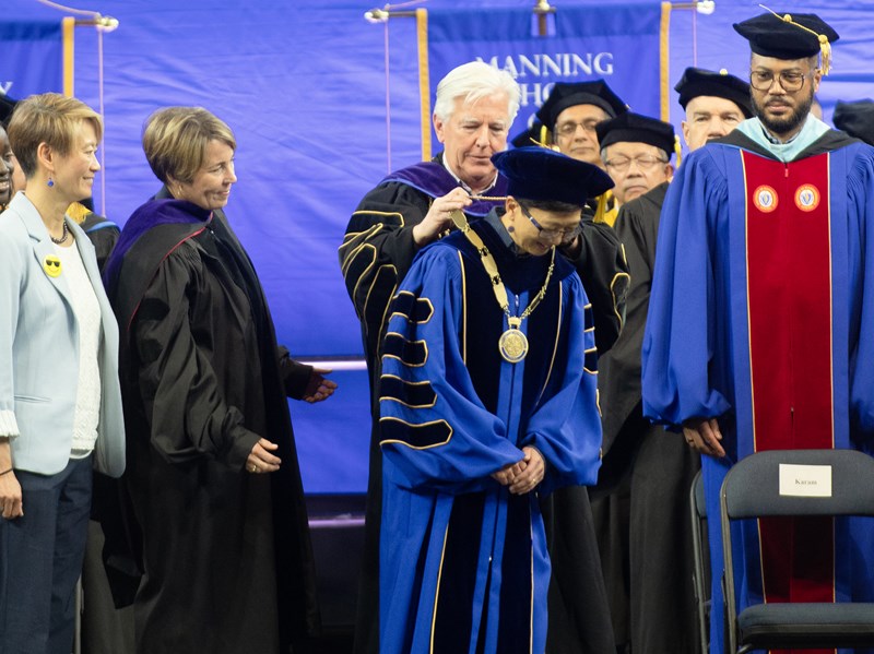 UMass President Marty Meehan dons the chancellor's medals on Chancellor Chen as Susu Wong and Gov. Healey look on