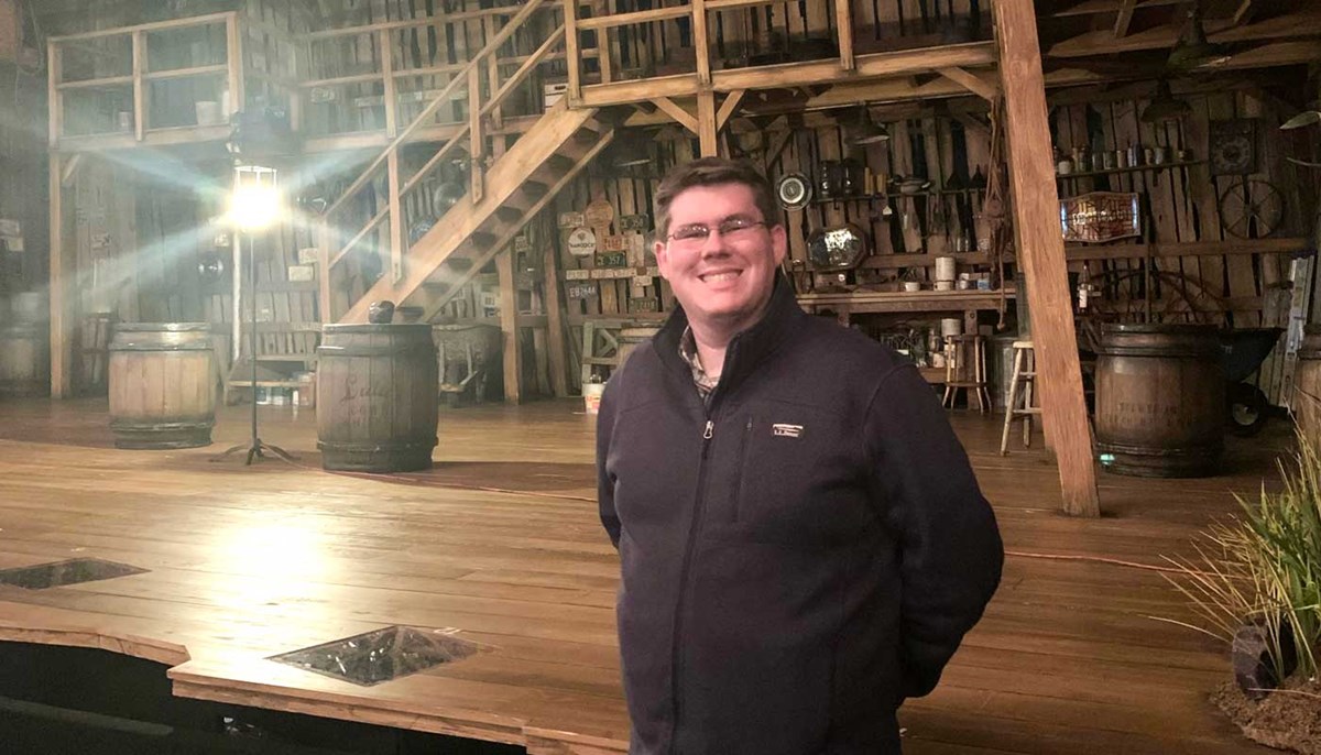 Dan Murphy poses in front of a theatre stage