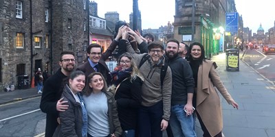 Dana Ibrahim, second from left in front, and fellow students touch a statue on street in Edinburgh, Scotland.