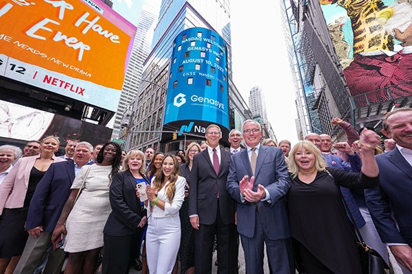 Richard Danforth Stands with family and friends on a street in New York as his company's stock is posted on a digital billboard.