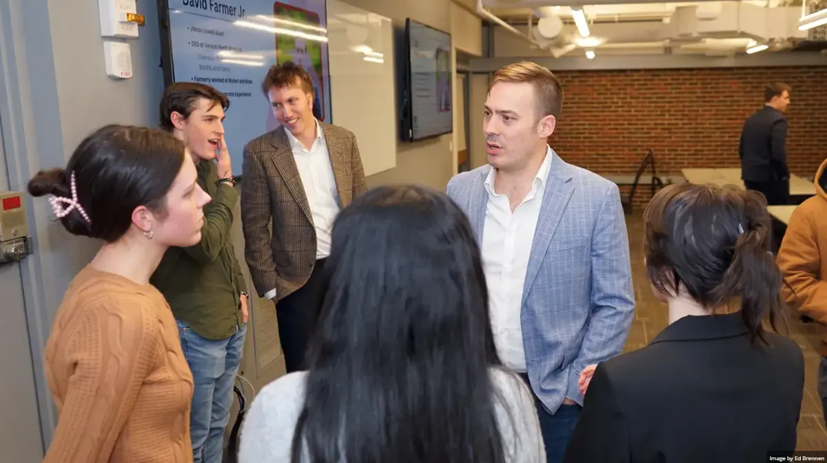 Group of students speaking with visiting alum