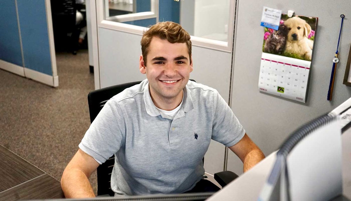 David Levine, UMass Lowell accounting student, seated in an office cubicle